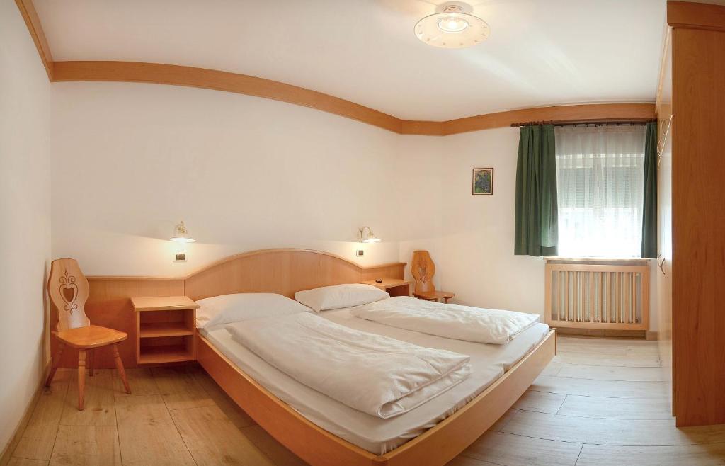 sypialnia z łóżkiem, stołem i oknem w obiekcie Casa Roder by Garni Snaltnerhof w mieście Ortisei