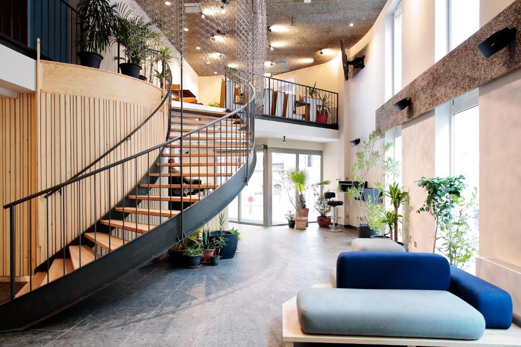 a lobby with a staircase and potted plants at Maverick Urban Lodge in Budapest
