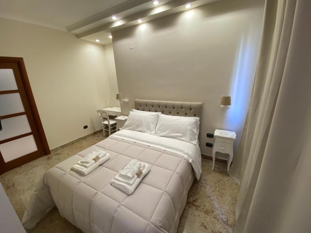 1 dormitorio con 1 cama blanca y 2 toallas en B&B San Michele Foggia, en Foggia