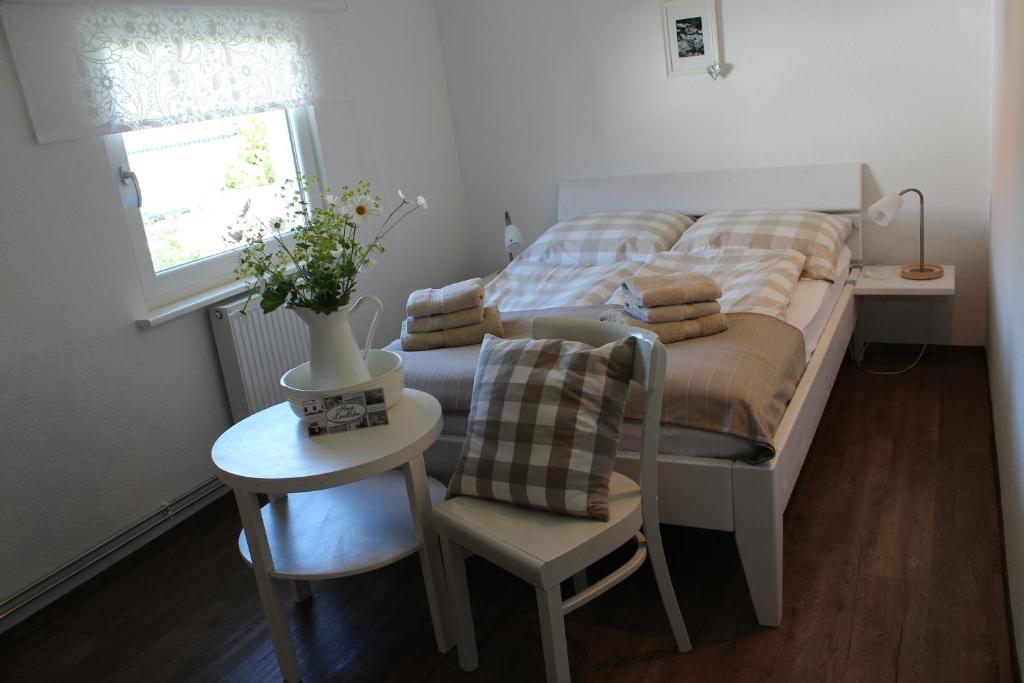 a bedroom with a bed and a table with a chair at KLEINE LANDLIEBE in Hohwacht