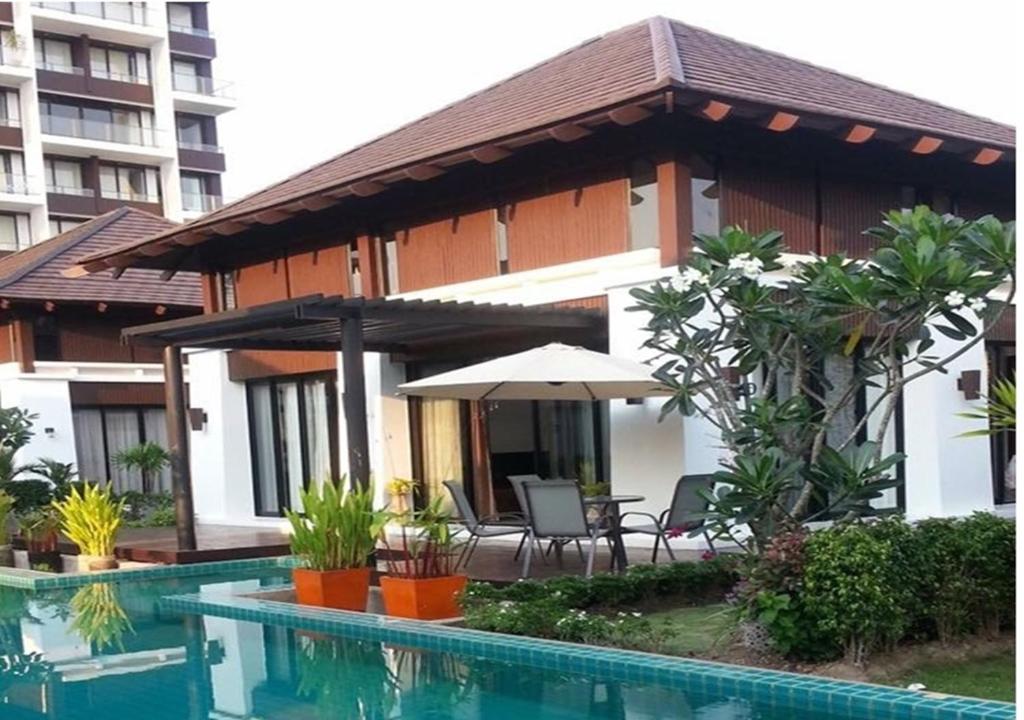 a house with a swimming pool next to a building at Pool Villa PB6rayong in Rayong