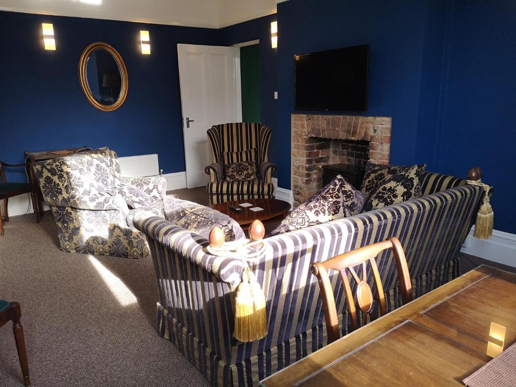 a living room with a couch and a fireplace at 2 Bedroom Apartment at Kent Escapes Short Lets & Serviced Accommodation Kent, Bouverie Escape Folkestone with Wifi in Folkestone