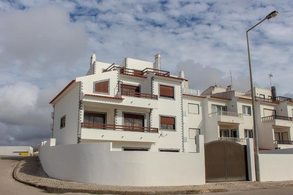 um edifício branco com uma cerca em frente em Casa Mar Campo em Santa Cruz