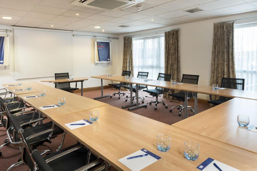 a conference room with wooden tables and chairs at Holiday Inn Express Birmingham Star City, an IHG Hotel in Birmingham