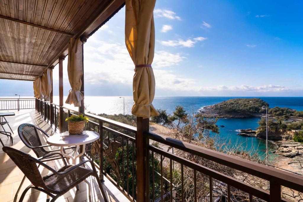 a balcony with chairs and a table and the ocean at Archodissa Pansion in Alyki