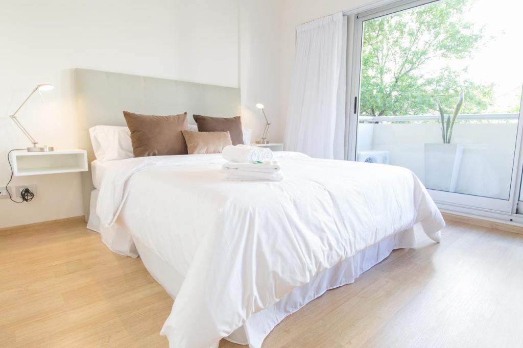 Un dormitorio blanco con una gran cama blanca y una ventana en New & Light in Belgrano 4C en Buenos Aires