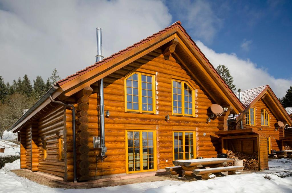 Cabaña de madera con mesa de picnic en la nieve en Luxus-Ferienhaus Blockhaus Chalet Nr 3 Toplage am Feldberg mit Sauna, Outdoor-Hottub, Kamin auf 1300m üM en Feldberg