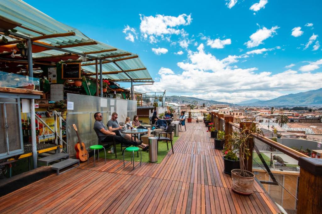 persone sedute ai tavoli sul ponte di un edificio di The Secret Garden a Quito