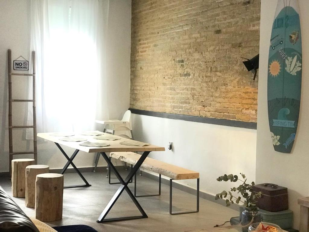 una habitación con una mesa y una tabla de surf en la pared en Cabanyal Beach House en Valencia