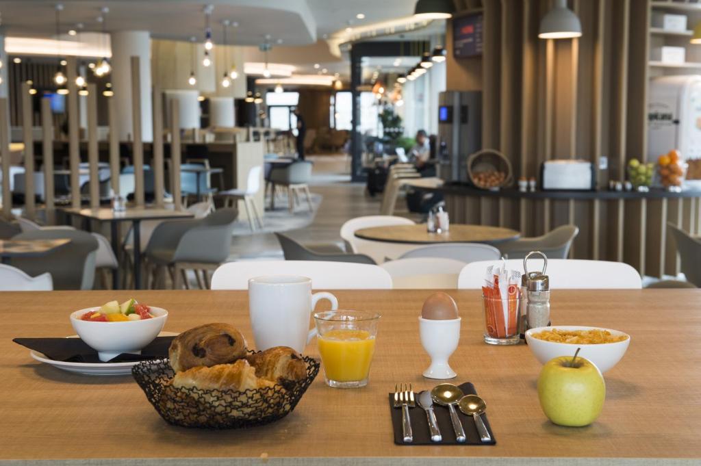a table with a bowl of food and drinks on it at Holiday Inn Express - Paris - CDG Airport by IHG in Roissy-en-France