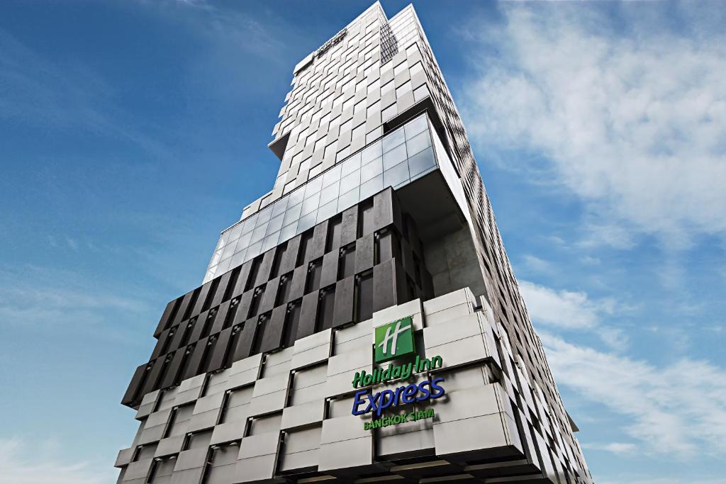 Un palazzo alto con un cartello sul lato. di Holiday Inn Express Bangkok Siam, an IHG Hotel a Bangkok