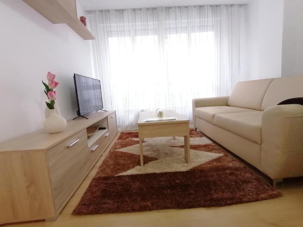 - un salon avec un canapé blanc et une télévision dans l'établissement APARTAMENTO BOLBORETA, à Pontevedra