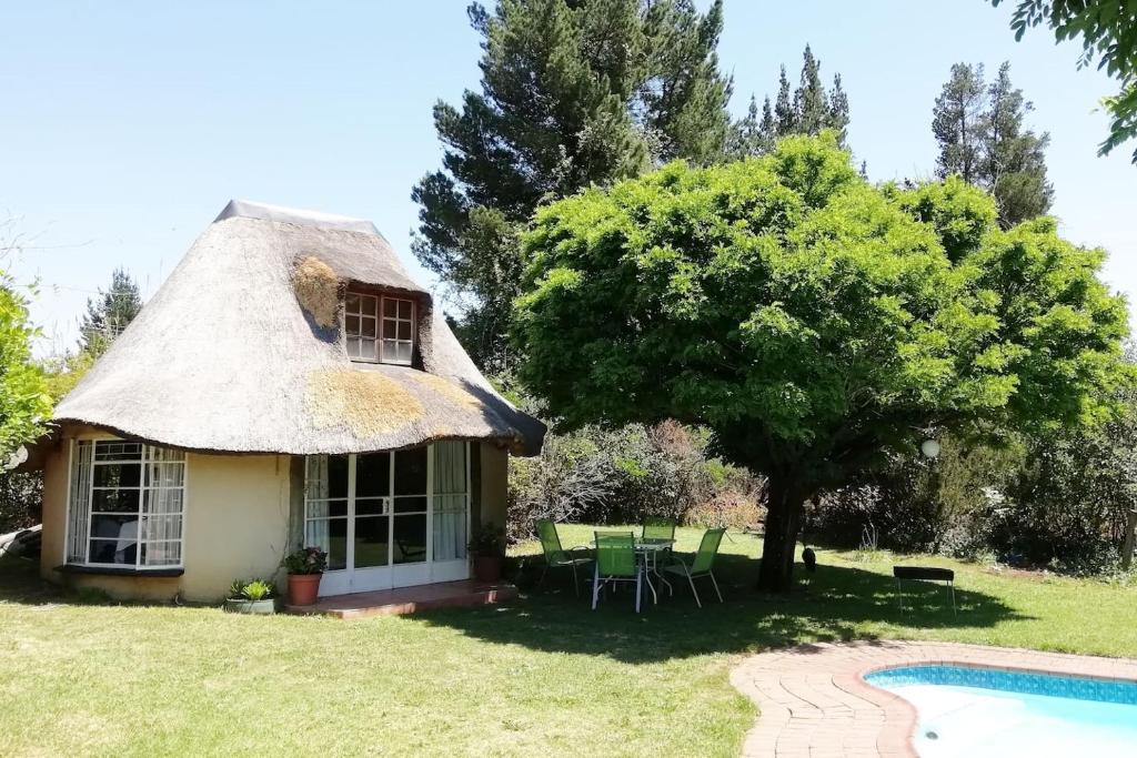 a thatch roofed cottage with a swimming pool at Clarens socialites, Thatch Cottage #1 in Bethlehem