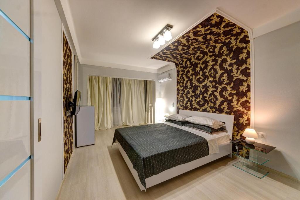 a bedroom with a bed and a wall at Шикарная 2к квартира Большая Васильковская 145, Оушен Плаза in Kyiv