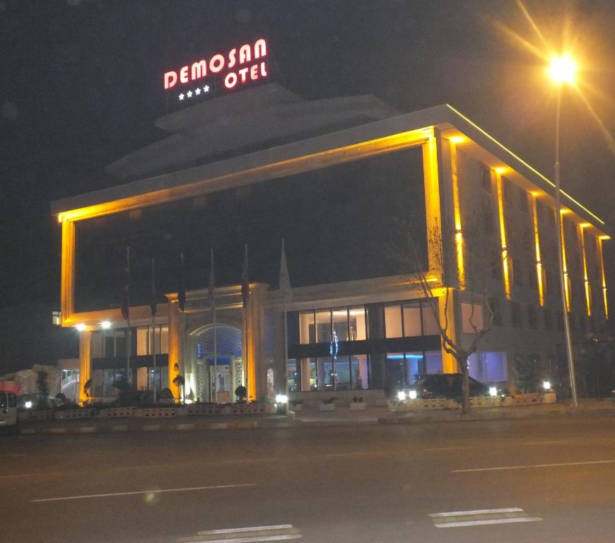 duży budynek z znakiem na górze w nocy w obiekcie Demosan Hotel w mieście Karaman