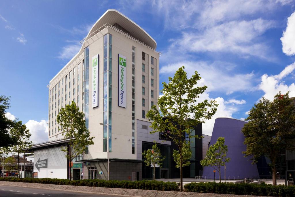 een hoog wit gebouw met een boom ervoor bij Holiday Inn Express Hull City Centre, an IHG Hotel in Hull