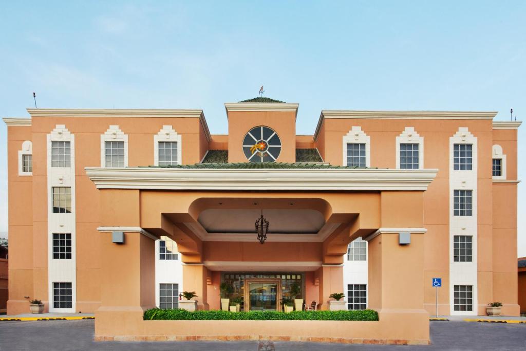 un grande edificio arancione con un orologio in cima di Holiday Inn Express - Monterrey - Tecnologico, an IHG Hotel a Monterrey