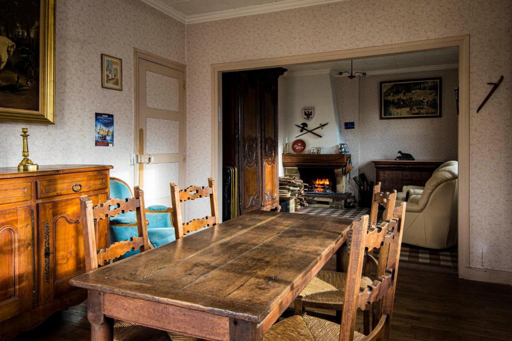 ein Esszimmer mit einem Holztisch und Stühlen in der Unterkunft Chambres d'hôtes GOBILLON in Maintenon
