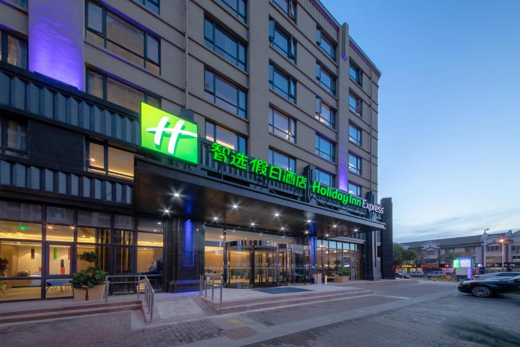 a building with a sign on the front of it at Holiday Inn Express Zhangjiagang East, an IHG Hotel in Zhangjiagang