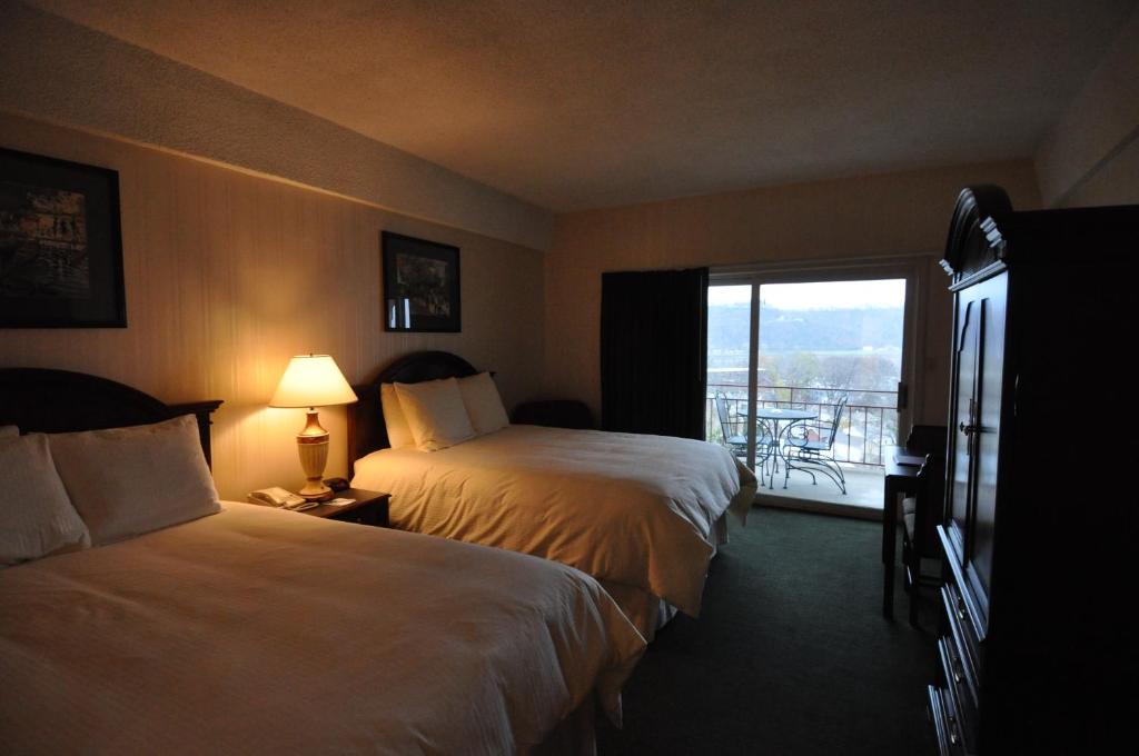 a hotel room with two beds and a balcony at Hillside Inn in Madison