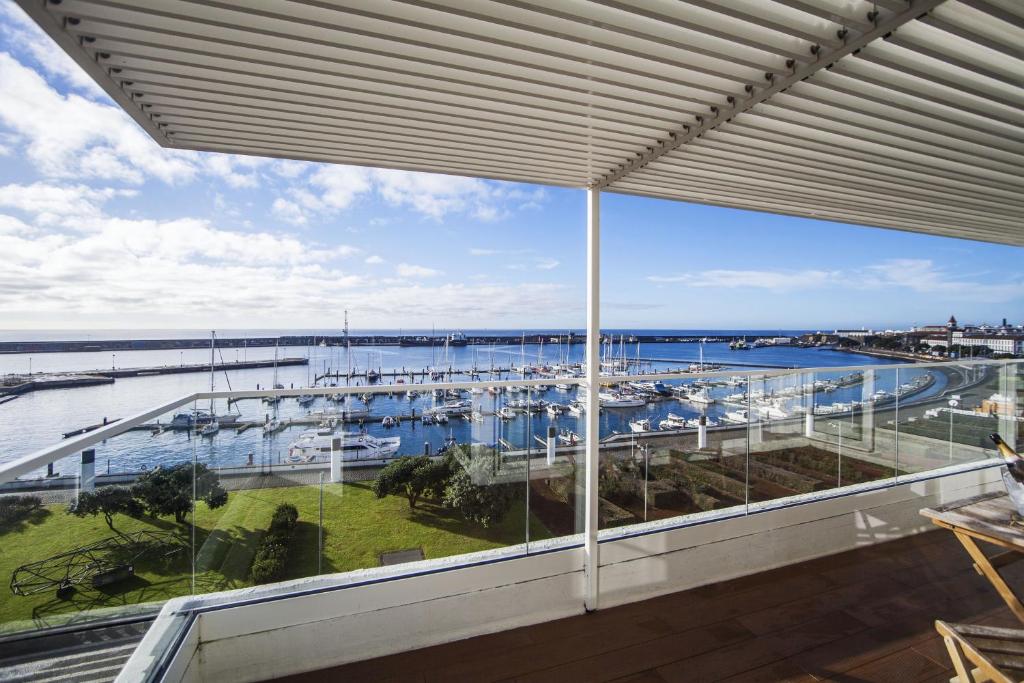 een groot raam met uitzicht op een jachthaven bij Hotel Gaivota Azores in Ponta Delgada