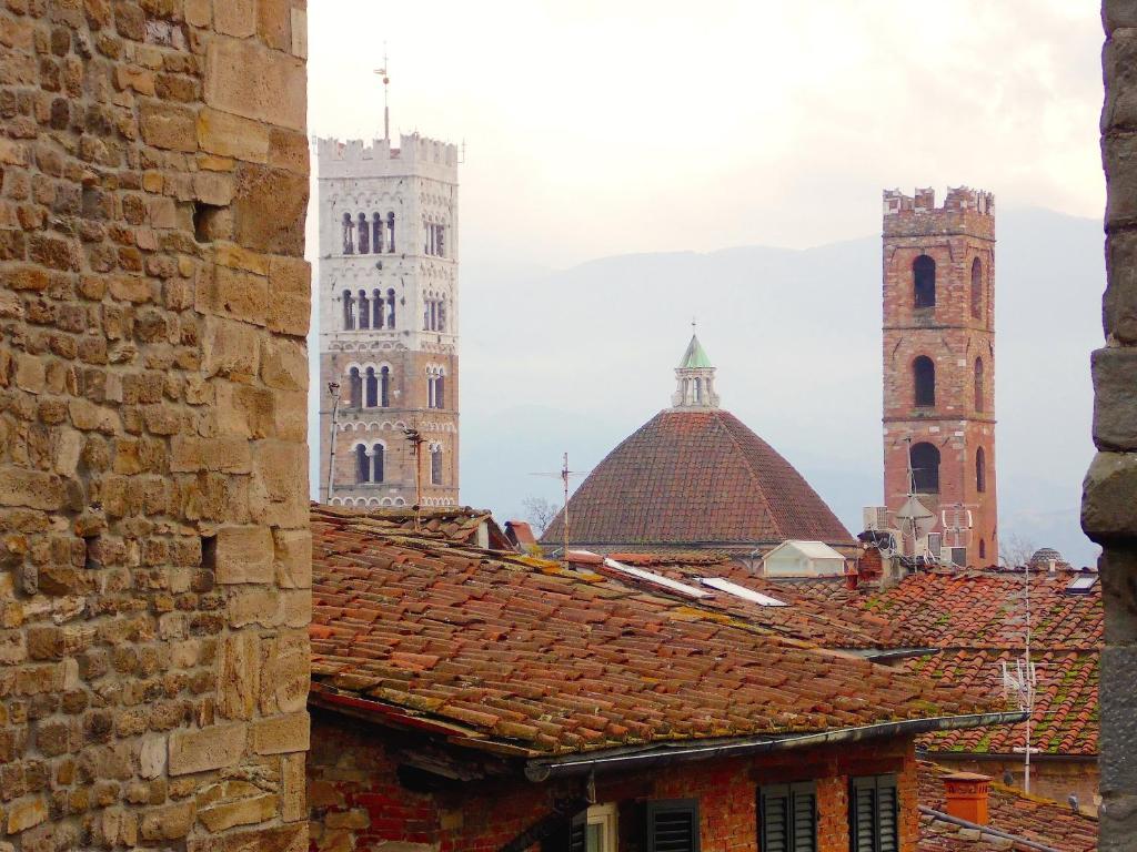 a view of two towers and roofs of a city at casa silvia in Lucca