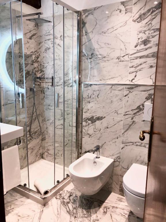 a bathroom with a shower and a sink and a toilet at Hotel Ariel Silva in Venice