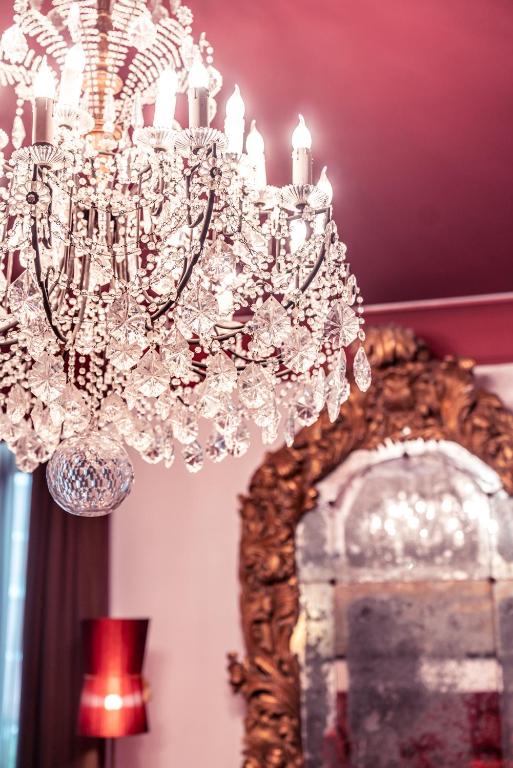 a chandelier hanging over a mirror in a room at Excess Venice Boutique Hotel & Private Spa - Adults Only in Venice