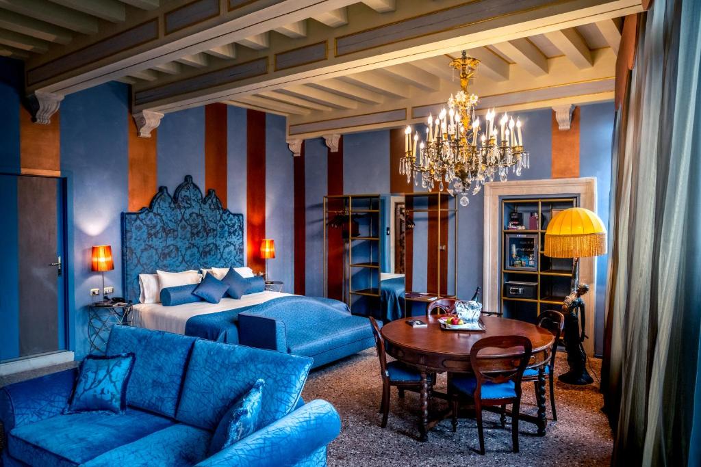 1 dormitorio con cama, mesa y muebles de color azul en Excess Venice Boutique Hotel & Private Spa - Adults Only, en Venecia