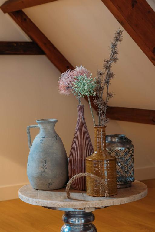 three vases sitting on a table with flowers in them at Hotel ML in Haarlem