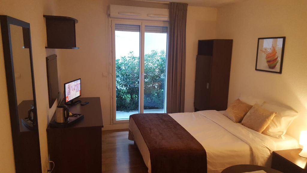 マルセイユにあるレジデンス プロバンスのベッドと窓が備わるホテルルーム