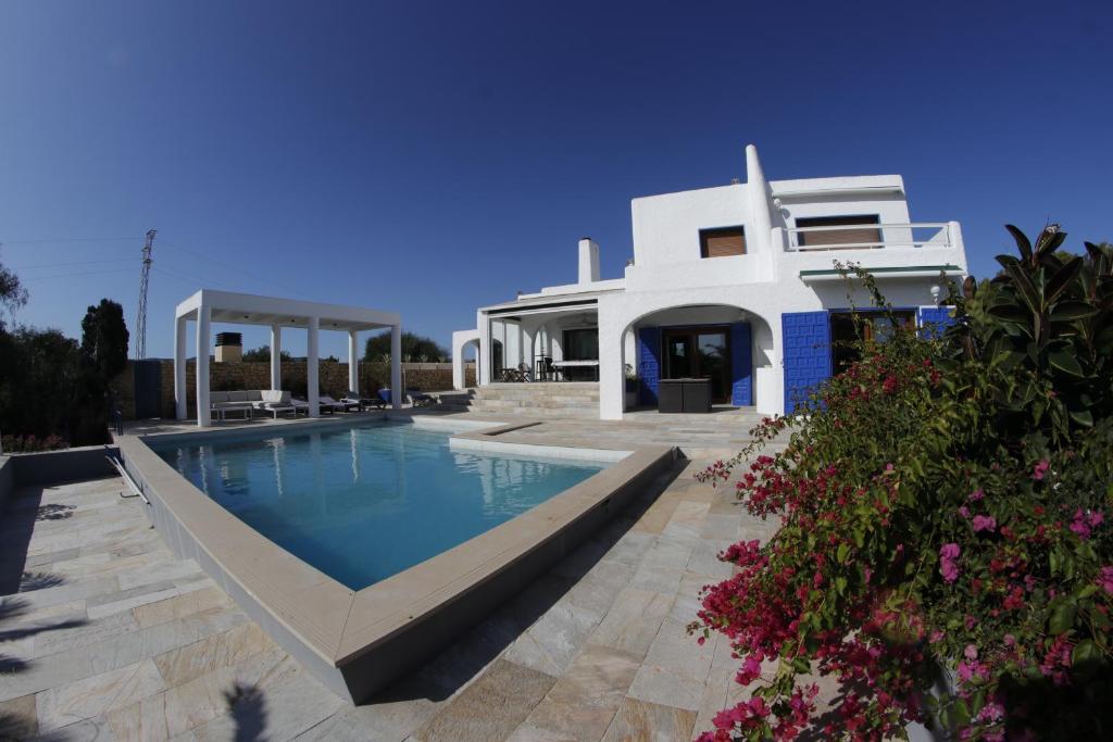 a villa with a swimming pool in front of a house at Villa Teresa in Agua Amarga