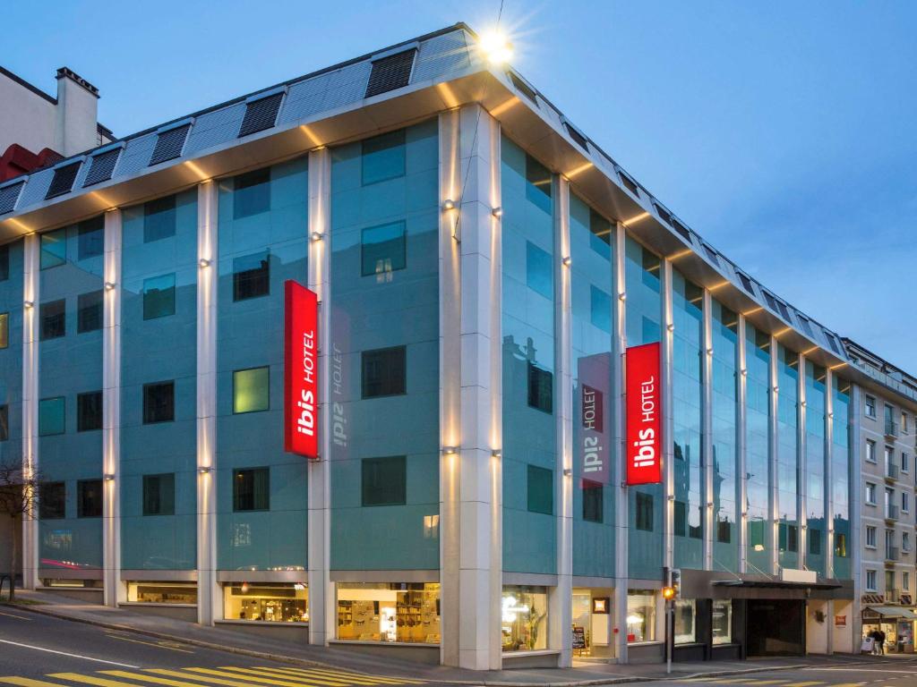 un grand bâtiment bleu avec des panneaux rouges dans l'établissement ibis Lausanne Centre, à Lausanne