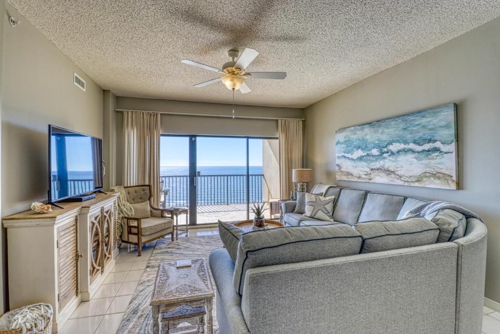a living room with a couch and a flat screen tv at The Palms #1002 in Orange Beach