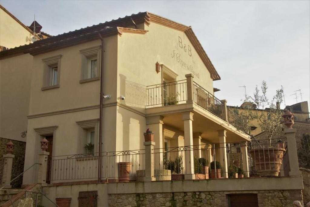 ein weißes Haus mit Balkon auf einem Gebäude in der Unterkunft B&B Il Sogno del Pinzagrilli in Guardistallo
