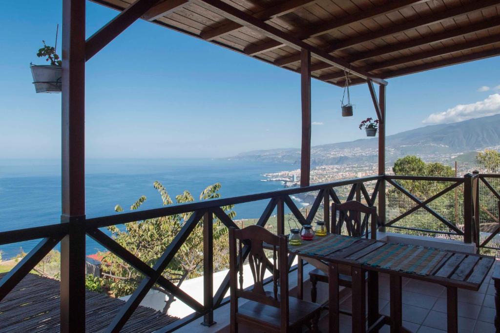 a table and chairs on a balcony with a view of the ocean at CASAS EN FINCA ECOLÓGICA EL BICLEN, NATURALEZA, CALMA Y VISTAS al MAR, in Icod el Alto