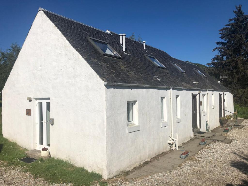 a white house with a black roof at Barfad Self Catering Holiday Cottages in Tarbert