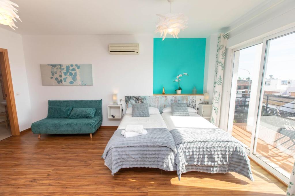 馬拉加的住宿－Your home by the sea，一间卧室配有一张大床和一张绿色沙发