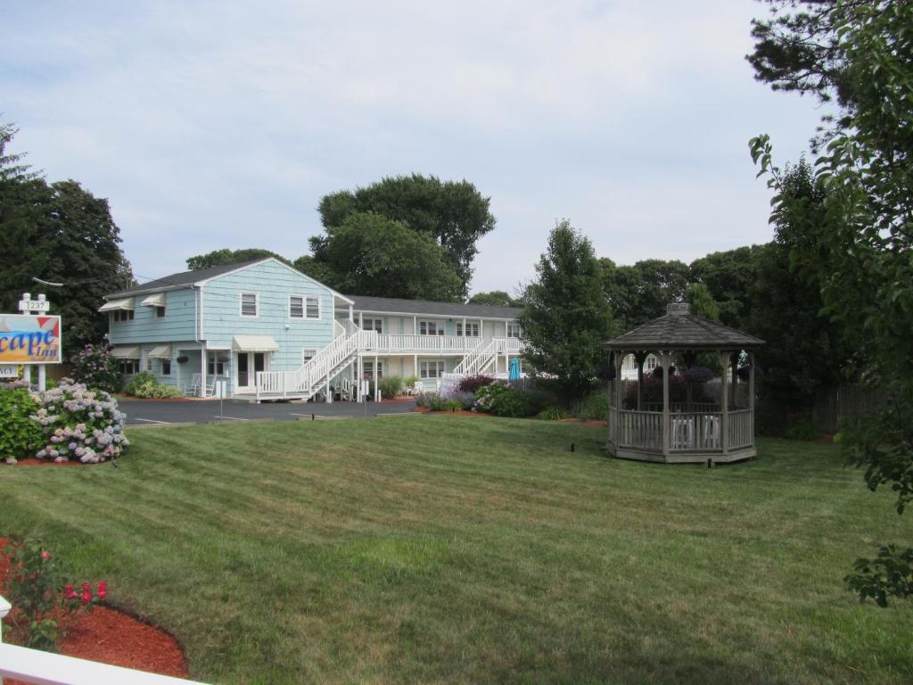 a gazebo in a yard in front of a house at The Escape Inn in South Yarmouth