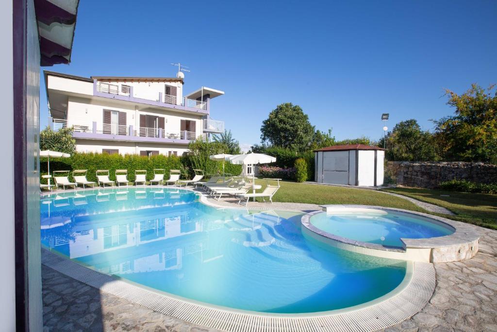 a swimming pool in front of a house at Selenite in Capo dʼOrlando