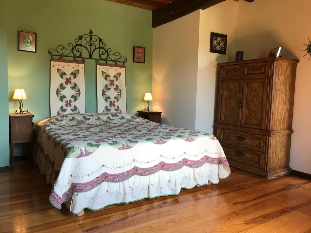 LarroqueにあるDomaine Du Colombier, Gite La Renaissanceのベッドルーム(大型ベッド1台、ドレッサー付)