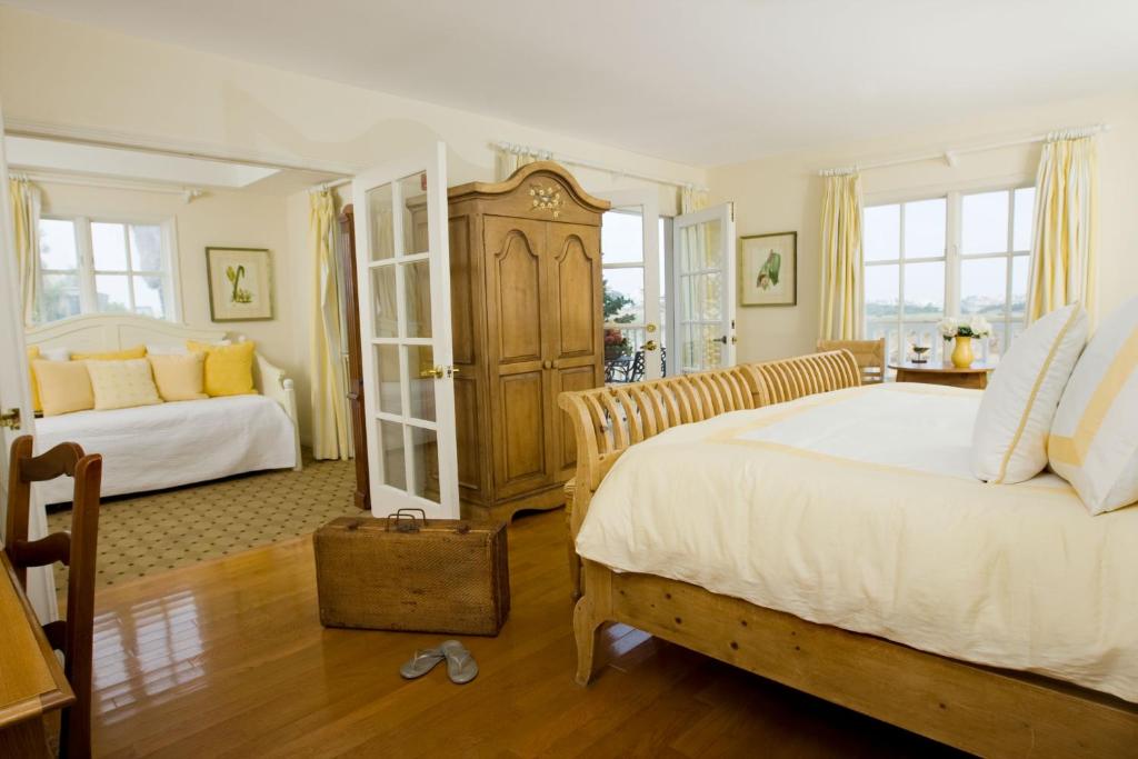 a bedroom with two beds and two windows at Inn at Playa del Rey in Los Angeles