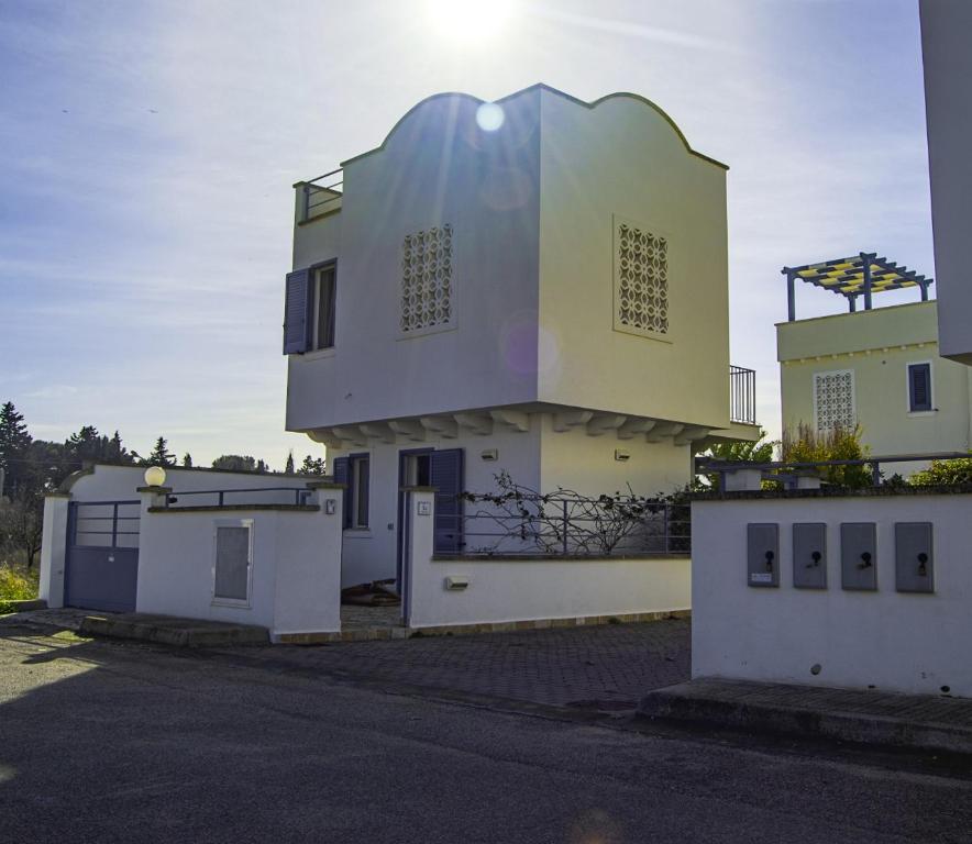a large white building with the sun shining on it at Villa Imma in Torre Lapillo