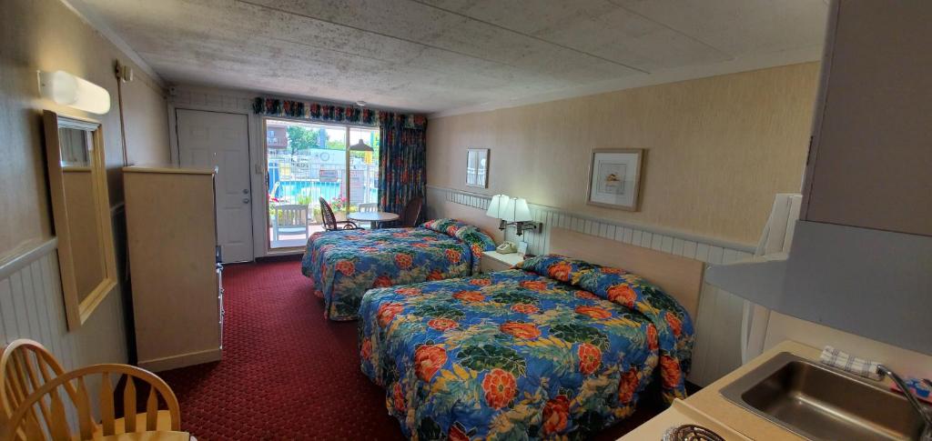 ein Hotelzimmer mit zwei Betten und einem Waschbecken in der Unterkunft Shangri-La Motel in Ocean City