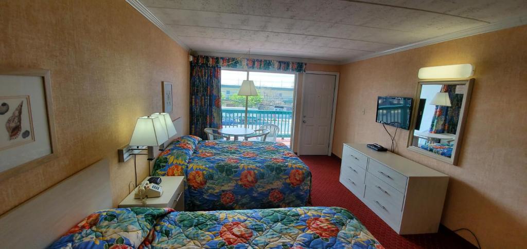 ein Hotelzimmer mit zwei Betten und einem Fenster in der Unterkunft Shangri-La Motel in Ocean City