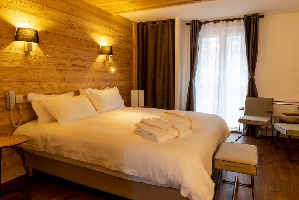 Una habitación de hotel con una cama con toallas. en Hotel SNOW CHILL en Risoul