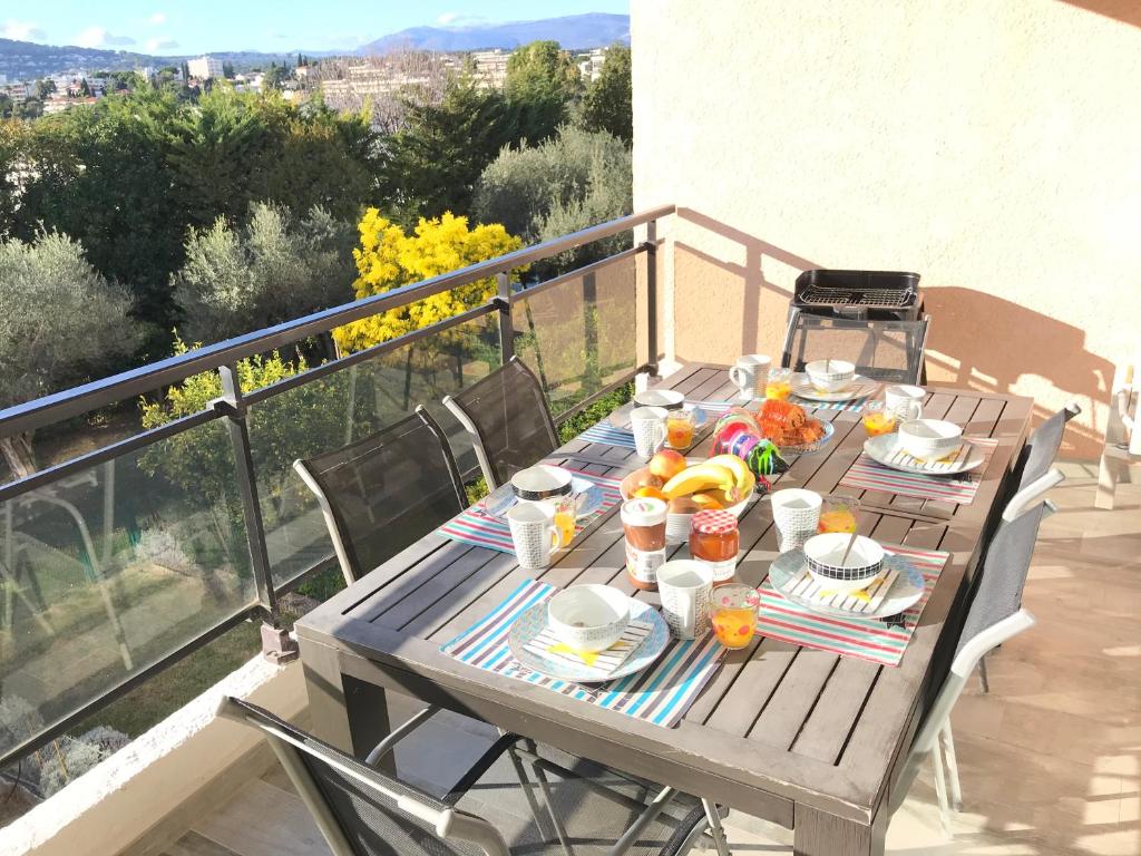a wooden table with food on top of a balcony at Appartement 3 pieces, refait a neuf, haut standing, piscine, mer a pieds in Antibes