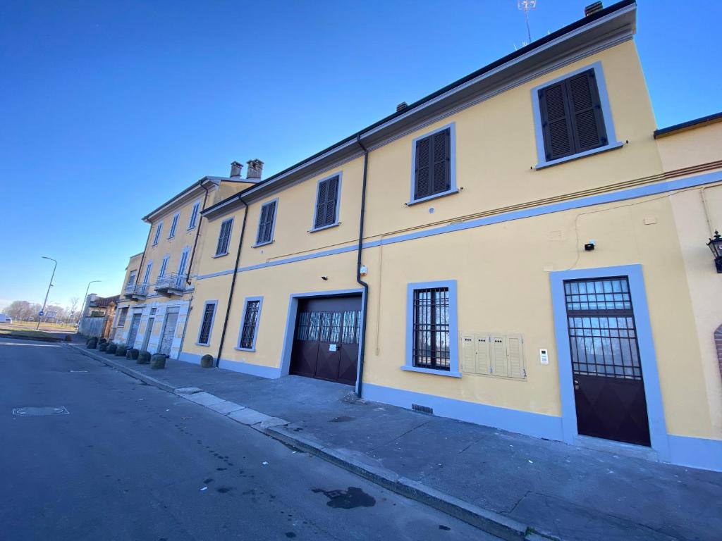 een lege straat naast een geel gebouw bij Novi Homes in Milaan