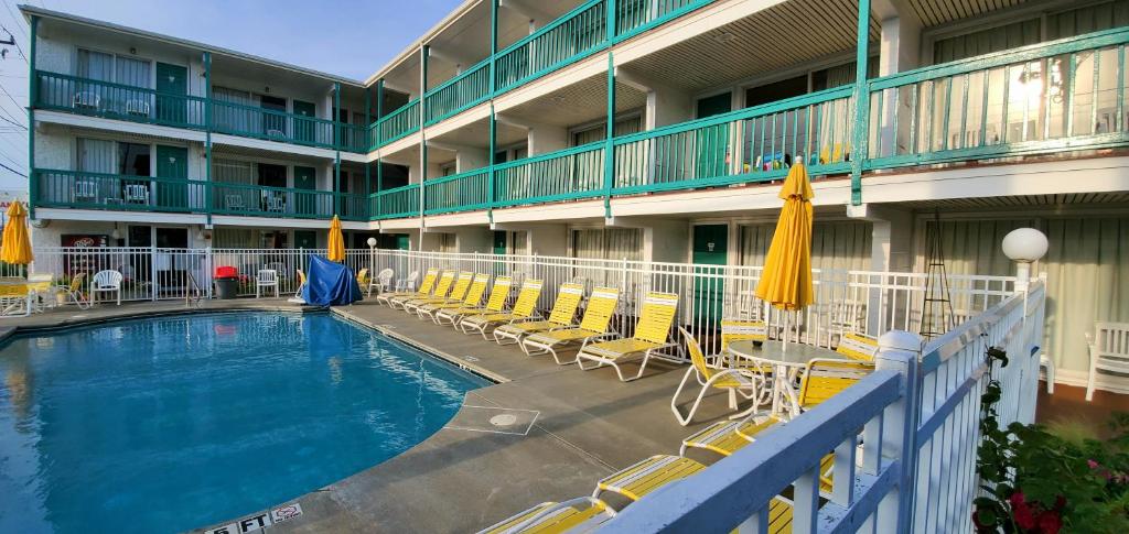 ein Swimmingpool in einem Hotel mit Stühlen und Sonnenschirmen in der Unterkunft Shangri-La Motel in Ocean City