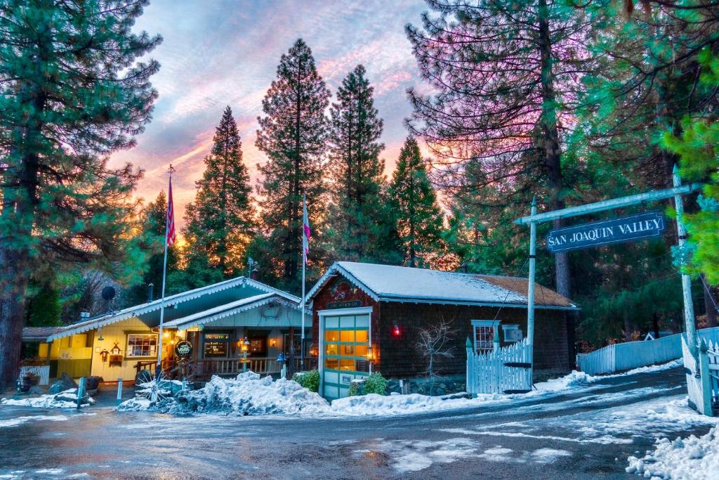 a building with a sign in front of a forest at Narrow Gauge Inn in Fish Camp